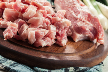 Raw pork belly pieces on a cutting board