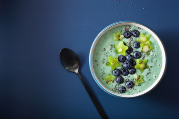 healthy spirulina smoothie bowl with blueberry, kiwi stars, chia seed