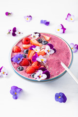 healthy summer berry smoothie bowl with flowers and chia seed