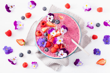 healthy summer berry smoothie bowl with flowers and chia seed