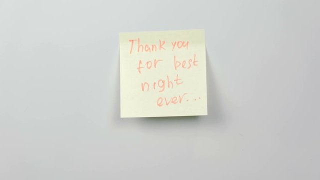 Closeup woman's hands stick yellow sticker paper sheets with words thank you for best night ever.