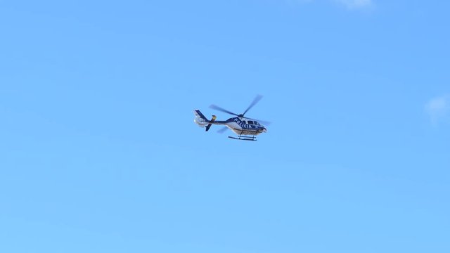 Police helicopter keep order fly over public center streets during carnival days in Tenerife