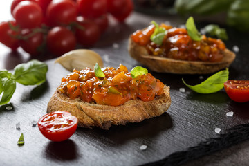Homemade Italian antipasto called Bruschetta topped with tomatoes, garlic, red pepper and basil