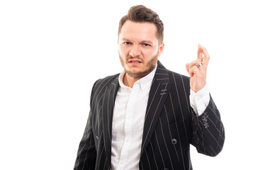 Portrait of business man showing cross fingers gesture.