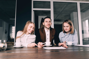 Office business people during a discussion, coffee pauses. One man and two women emotionally...