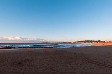 Narrabeen Beach, Sydney in the morning with clear blue sky.