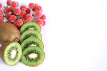 A kiwi fruit is sliced on a white background