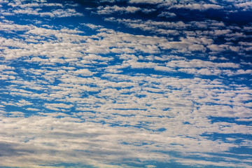 The blue cloudy sky on bright natural background.