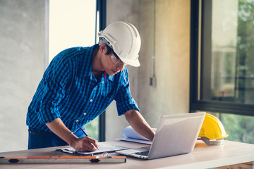 Architect & Engineer working drawing document about project planning and progress of work schedule on the home building construction site
