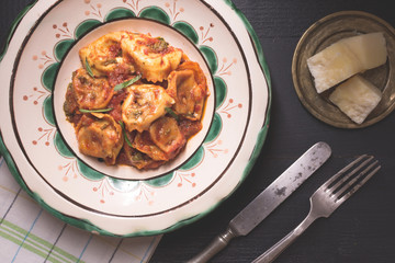 Traditional Italian Tortellini with Tomato Sauce, Mozzarella Cheese and Basil on Rustic Plate