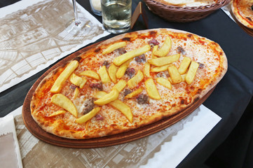 traditional italian pizza with potato fries, sausages, cheese and tomato sauce - famous italian food 