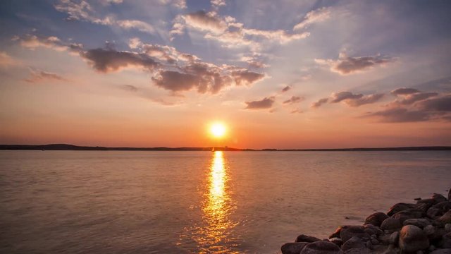 Amazing sunset with sunlight way on water over seascape. Nature landscape in motion. High quality 4K resolution. Timelapse footage.
