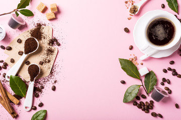 Food background with ground coffee in spoons, coffee beans, espresso cup, ground and capsules, green leaves, copy space, top view.