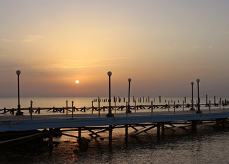 Fototapeta na wymiar Sunrise on the sea. Pier stretching into infinity. Morning sun rays. Red sea, Safaga, Egypt.