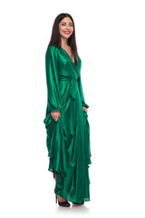 Naklejka premium smiling brunette girl holding her green gown while standing