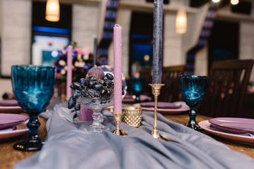 Naklejka premium Details of decorating of a wedding: candles, flowers and candlesticks.