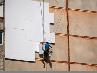 Insulation and Energy Saving Technology Concept. Worker Making Building with heat insulated facade