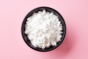 Bowl of powder sugar on white background, from above - Powered by Adobe
