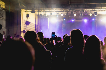 Tel Aviv, Israel February 23, 2018: Person taking a picture of a concert with purple fog and a bright stage area