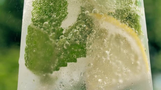 Glass with lemon, mint and ice. Refreshing sparkling drink.