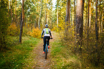 Fototapeta premium Image from back of girl in helmet on bicycle