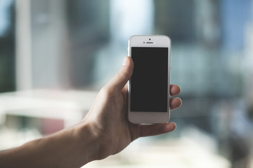 Hand holding white smart phone