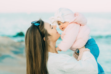 Mother with her daughter playing on the beach.