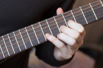 Fototapeta na wymiar Man is playing guitar close up