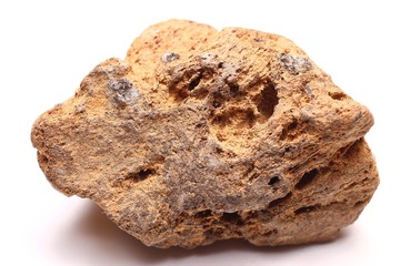 A piece of pumice resembling a meteorite on a white background
