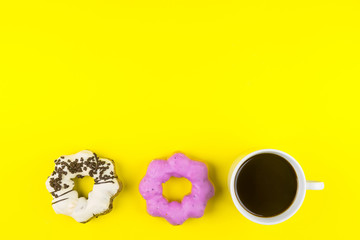 Obraz na płótnie Canvas Donut made at home with White Coffee Cup of Espresso on yellow background.Breakfast in the morning rush hour.High energy foods to work.Foods with very high caloriese, sugars and caffeine.