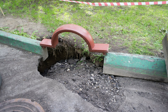 Broken asphalt. A hole in the sidewalk. Repair of road works.