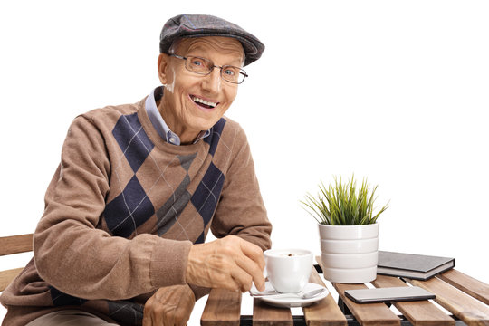 Elderly man sitting at a coffee table and smiling