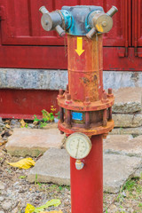 Old fire extinguisher for connecting with fire hose in community.
