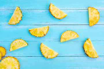 Tropical pineapple slices on wood plank blue color. frame layout summer vacation background concept. top view, pattern