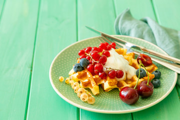 Breakfast with waffles, wipped cream, berries and granola