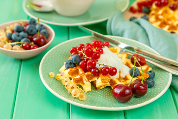 Breakfast with waffles, wipped cream, berries and granola