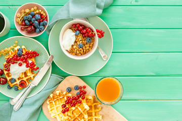 Breakfast with waffles, wipped cream, berries and granola