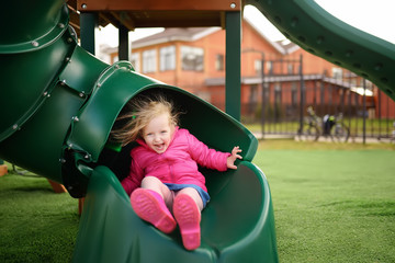 Cute little girl having fun on outdoor playground