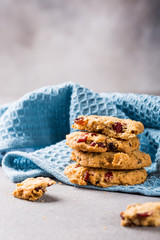 Oat meal cookies with raisins and cranberries on light gray background and blue napkin. Health breakfast or snack concept