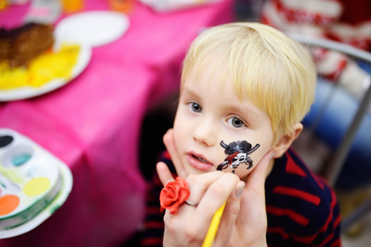 Face painting for cute little boy during kids birthday party