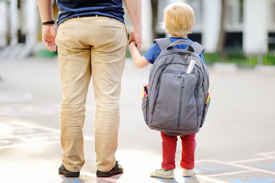 Back to school concept. Little pupil with his father. First day of primary school.