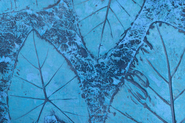 Pattern of leaf stamped on blue pastel concrete pavement for decorate walkways in the garden.