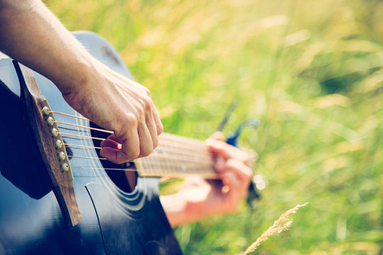 Musizieren mit Gitarre in der Wiese, Gitarrenkorpus, Hals und H&auml;nde, Freiraum