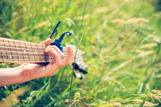 Musizieren mit Gitarre in der Wiese, Gitarrenhals, Freiraum