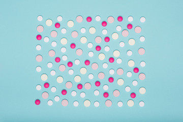 Assortment of various colourful pills isolated on blue pastel coloured background. Medication and prescription pills flat lay background.
