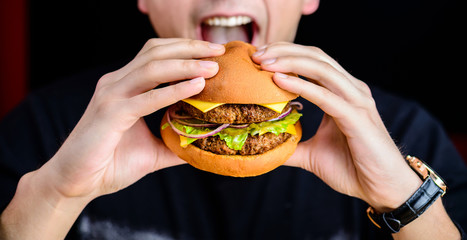 Process of eating delicious Burger served with beef, cheese and 