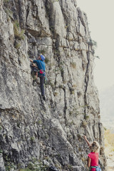 Man and Woman Climbers Climbing a Rock