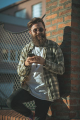 handsome hipster modern man using smart phone in the city