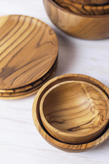 Wooden utensils for the kitchen, bowls, plates on a light background. The concept of natural dishes, a healthy lifestyle. Texture of wood.