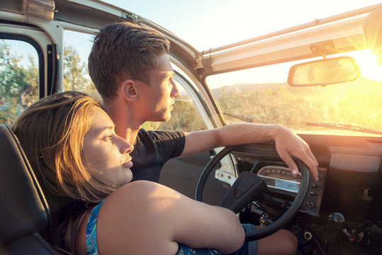 Couple looking at sunset in a car